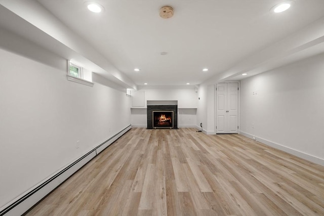 443 Great Plain Ave, Needham, MA 02492 - unfurnished living room with a baseboard heating unit, recessed lighting, light wood-style flooring, a warm lit fireplace, and baseboards