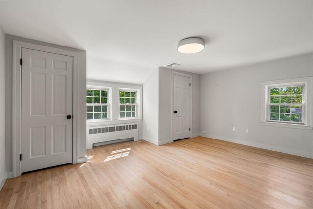 443 Great Plain Ave, Needham, MA 02492 - empty room with radiator, light wood finished floors, plenty of natural light, and baseboards