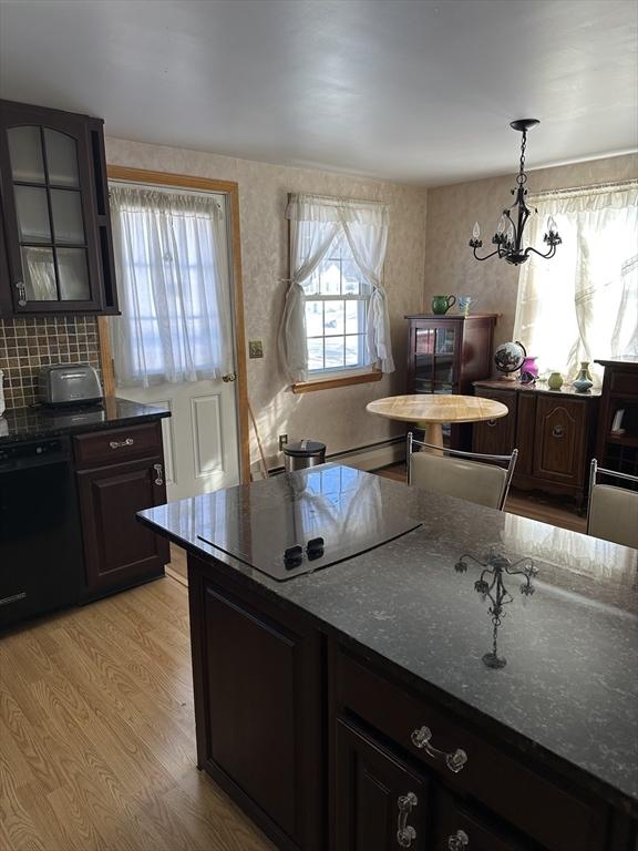 kitchen featuring pendant lighting, dark brown cabinetry, light hardwood / wood-style flooring, and black appliances