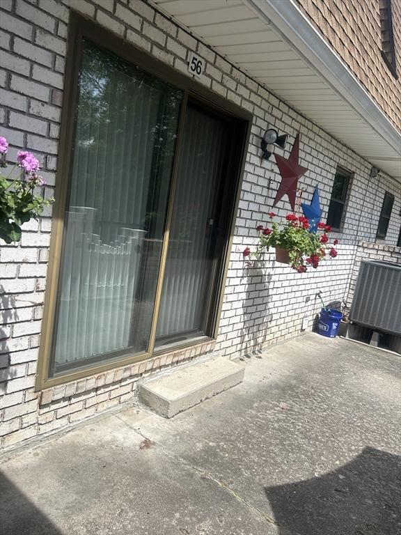 56 Granby Hts Unit 56, Granby, MA 01033 - property entrance featuring brick siding and cooling unit