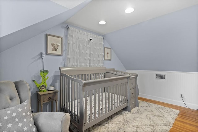 12 Willow St, Wakefield, MA 01880 - bedroom with wood finished floors, a nursery area, vaulted ceiling, and wainscoting