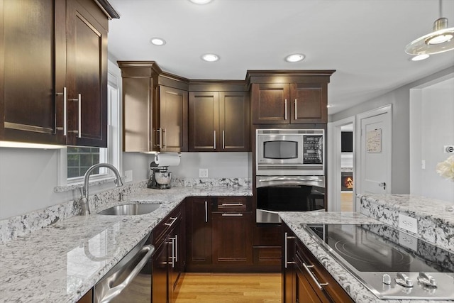 12 Willow St, Wakefield, MA 01880 - kitchen featuring appliances with stainless steel finishes, recessed lighting, light wood-style flooring, light stone counters, and dark brown cabinets