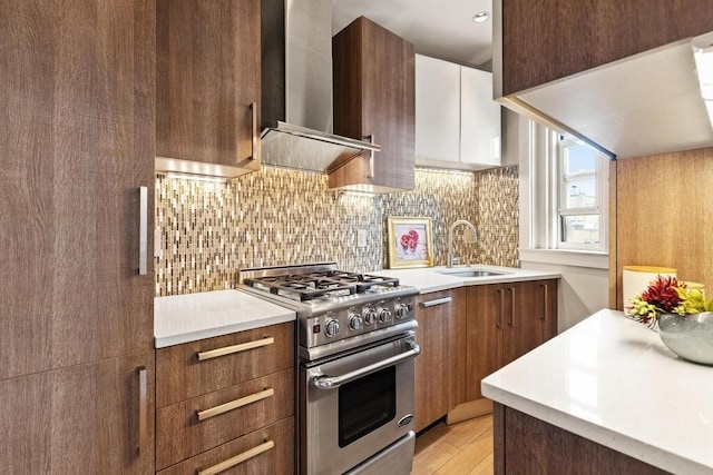 3 Arlington St Unit 31, Cambridge, MA 02140 - kitchen with high end stove, wall chimney exhaust hood, a sink, decorative backsplash, and light countertops
