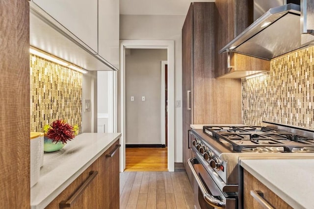 3 Arlington St Unit 31, Cambridge, MA 02140 - kitchen with gas stove, wall chimney range hood, light wood finished floors, and light countertops