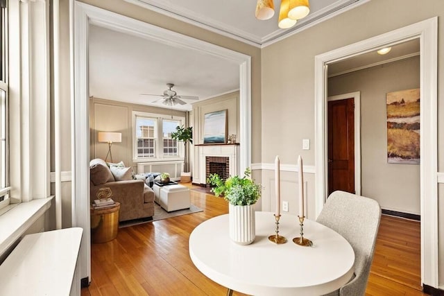 3 Arlington St Unit 31, Cambridge, MA 02140 - dining space with a brick fireplace, crown molding, light wood-style floors, a ceiling fan, and baseboards