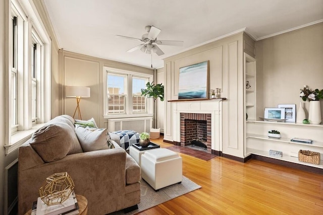 3 Arlington St Unit 31, Cambridge, MA 02140 - living room featuring a brick fireplace, wood finished floors, a ceiling fan, crown molding, and baseboards
