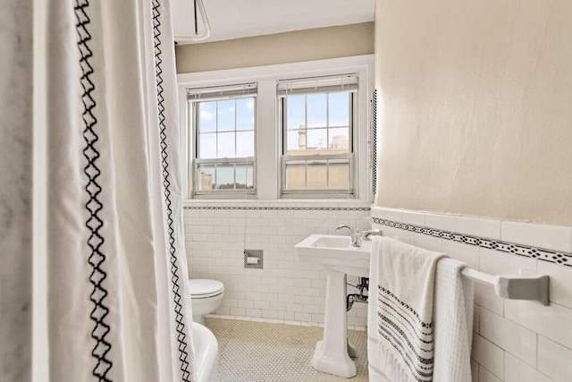 3 Arlington St Unit 31, Cambridge, MA 02140 - full bath featuring tile walls, toilet, tile patterned floors, wainscoting, and a sink