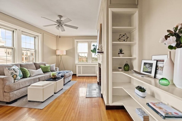 3 Arlington St Unit 31, Cambridge, MA 02140 - living room featuring radiator heating unit, light wood finished floors, ceiling fan, and built in shelves