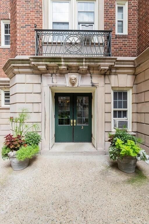 3 Arlington St Unit 31, Cambridge, MA 02140 - doorway to property featuring french doors, a balcony, and brick siding