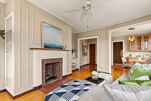 3 Arlington St Unit 31, Cambridge, MA 02140 - living room with ornamental molding, ceiling fan, light wood-type flooring, a fireplace, and baseboards