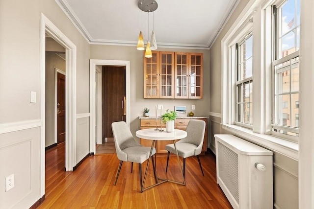 3 Arlington St Unit 31, Cambridge, MA 02140 - dining space with light wood finished floors, radiator, crown molding, and wainscoting