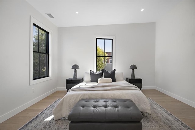 bedroom featuring light hardwood / wood-style floors and multiple windows