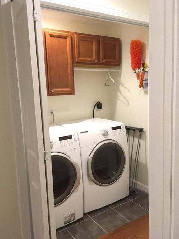 laundry room featuring cabinet space, separate washer and dryer, and dark tile patterned flooring