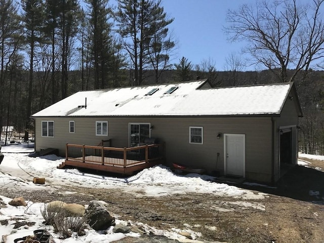 snow covered property with a wooden deck