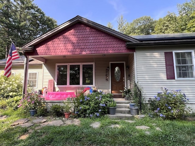 view of front of property with a porch and solar panels