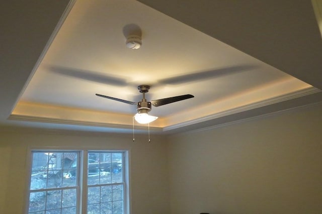 room details featuring ornamental molding, a raised ceiling, and a ceiling fan