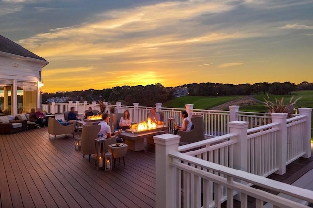 deck at dusk featuring an outdoor fire pit