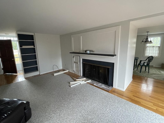living room featuring baseboards, a fireplace, and wood finished floors