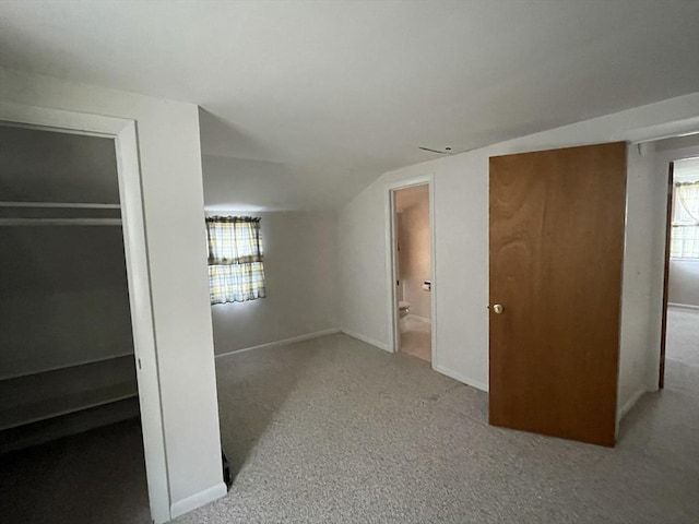 unfurnished bedroom with baseboards, carpet flooring, and ensuite bath