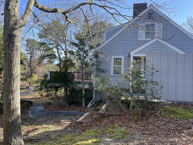 view of property exterior with a wooden deck and a chimney