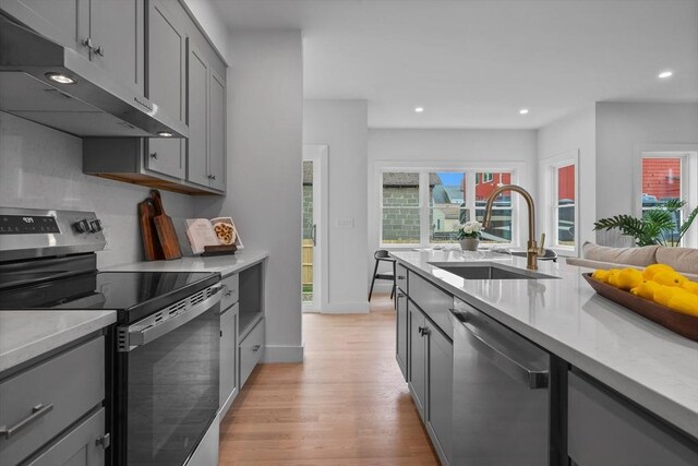 30A Emerald Rd Unit A, Nahant, MA 01908 - kitchen with appliances with stainless steel finishes, a sink, under cabinet range hood, gray cabinets, and light wood-type flooring