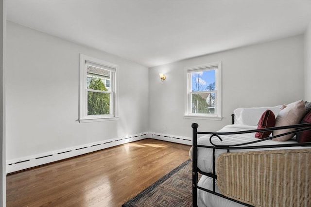 bedroom featuring wood finished floors and a baseboard radiator