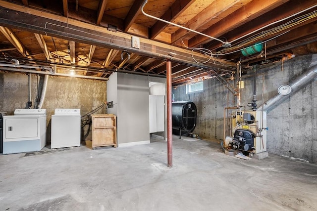 basement featuring a heating unit, heating fuel, and independent washer and dryer