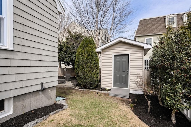 view of outbuilding featuring fence and an outbuilding