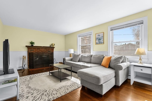 living area with a wainscoted wall, a fireplace, and wood finished floors