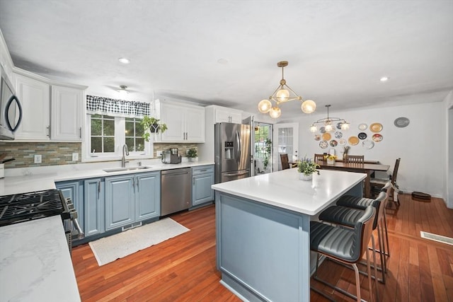 12 Wilson St, Randolph, MA 02368 - kitchen featuring stainless steel appliances, decorative backsplash, a center island, a kitchen breakfast bar, and white cabinetry