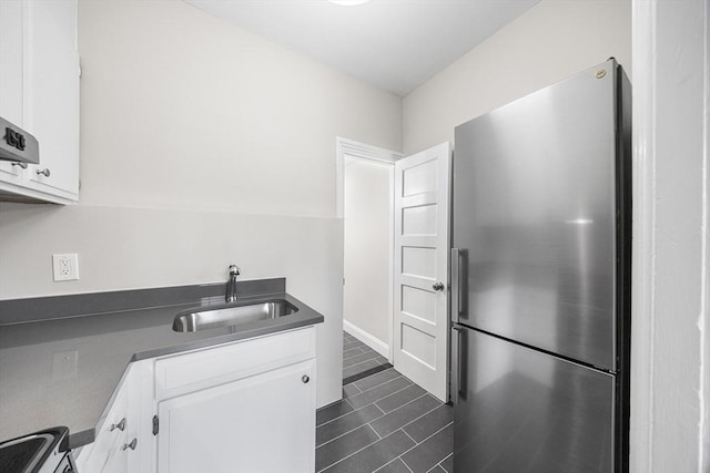 100 Charles St Unit 5, Boston, MA 02114 - kitchen with freestanding refrigerator, dark countertops, white cabinets, and dark tile patterned flooring