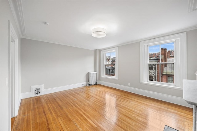 100 Charles St Unit 5, Boston, MA 02114 - empty room featuring radiator heating unit, light wood-style floors, ornamental molding, and a smoke detector