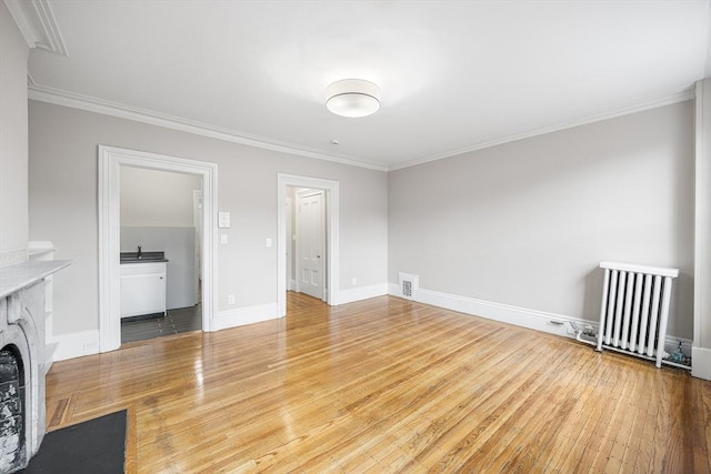 100 Charles St Unit 5, Boston, MA 02114 - unfurnished living room with ornamental molding, wood-type flooring, a fireplace with flush hearth, and radiator heating unit