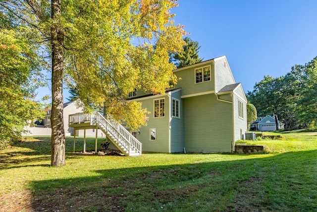 back of house featuring cooling unit, a deck, and a yard