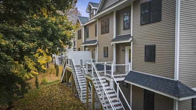 9 Acton Rd Unit 16, Chelmsford, MA 01824 - back of property featuring a wooden deck, stairway, and a shingled roof