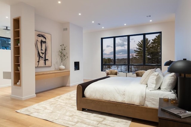 bedroom featuring visible vents, baseboards, wood finished floors, and recessed lighting