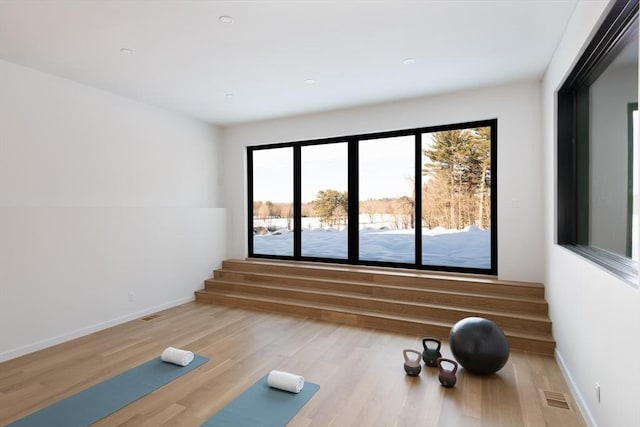 exercise room featuring visible vents, baseboards, and wood finished floors