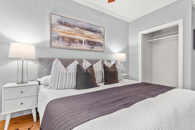 bedroom featuring ornamental molding, a ceiling fan, a closet, and wood finished floors