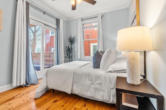 bedroom featuring baseboards, access to outside, ornamental molding, and wood finished floors