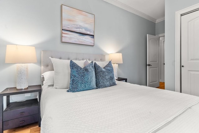 bedroom featuring a closet, wood finished floors, and crown molding