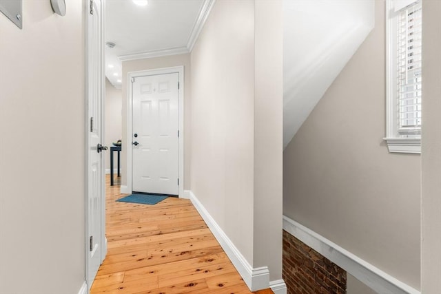 corridor with wood-type flooring, crown molding, and baseboards