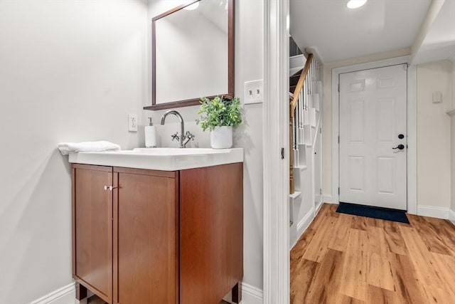 bathroom with baseboards, wood finished floors, and vanity