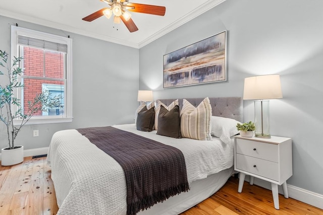 bedroom featuring baseboards, ceiling fan, hardwood / wood-style floors, and crown molding