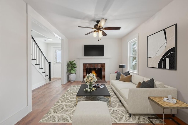 living room with hardwood / wood-style flooring, a fireplace, and ceiling fan