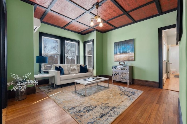 living room featuring baseboards, wood finished floors, and a wall mounted AC