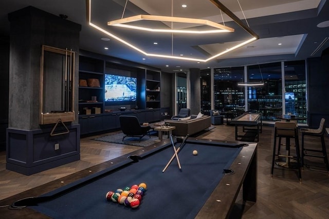 game room with a raised ceiling, dark parquet flooring, pool table, and built in features