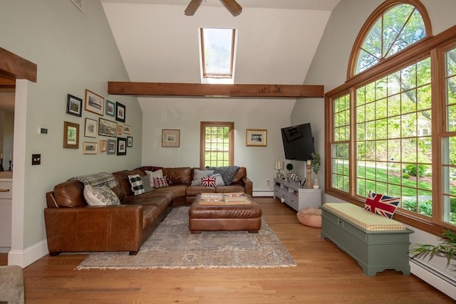 living room with high vaulted ceiling, ceiling fan, baseboard heating, healthy amount of natural light, and wood finished floors