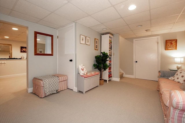 living area with carpet, a drop ceiling, recessed lighting, baseboards, and stairs