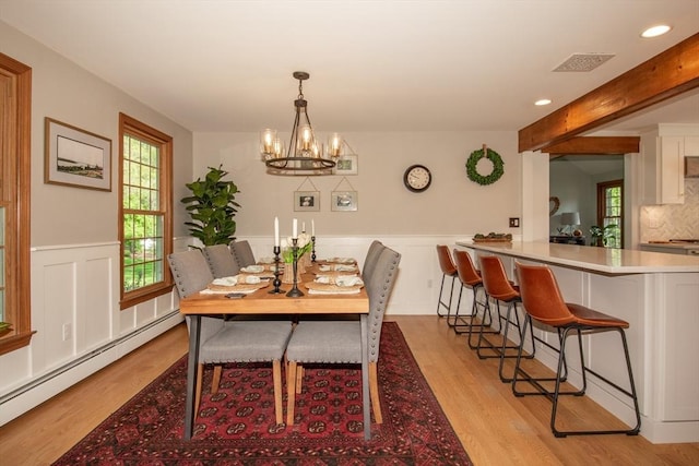 dining area featuring baseboard heating, light wood finished floors, recessed lighting, a chandelier, and wainscoting