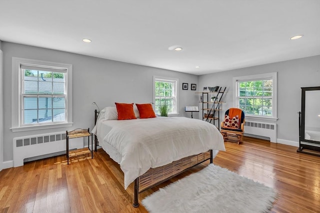 bedroom featuring radiator, wood finished floors, baseboards, and recessed lighting